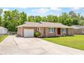 Charming brick home with a well-maintained lawn, long driveway, and a detached garage at 264 Columbia Dr, Ladson, SC 29456