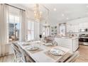 Airy dining area featuring large windows, a statement chandelier, and views of the living area at 308 Archar St, Summerville, SC 29486