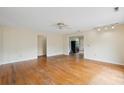 An empty living room with hardwood floors, a ceiling fan, and an open layout into the kitchen area at 3109 Ion Ave, Sullivans Island, SC 29482