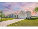 A well-maintained home with a two-car garage, complemented by lush greenery and a long driveway at 311 Beachgrass Ln, Summerville, SC 29486