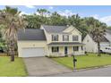 Charming two-story home featuring a welcoming front porch, two-car garage, and lush green lawn at 327 Eagle Ridge Rd, Summerville, SC 29485