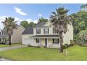 Charming two-story home featuring a welcoming front porch, two-car garage, and lush green lawn at 327 Eagle Ridge Rd, Summerville, SC 29485