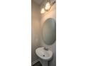 Cozy powder room featuring a pedestal sink, round mirror, and decorative lighting at 430 Pender Woods Dr, Summerville, SC 29486