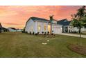 A quaint home with a manicured front yard, complemented by a beautiful sunset sky at 511 Ocean Mist Way, Summerville, SC 29486