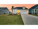 A beautiful home with a well-kept lawn, two car garage, and inviting entryway at sunset at 511 Ocean Mist Way, Summerville, SC 29486