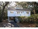 Charming coastal home with a inviting porch, staircase, and an elevated foundation amidst lush foliage at 555 Double Eagle, Seabrook Island, SC 29455