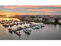 Aerial view of a serene marina with boats docked along the pier under a colorful sky at 63 Mariners Cay, Folly Beach, SC 29439