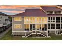 Charming exterior view of a condo with a red roof, gray siding, and stairway to the entrance at 63 Mariners Cay, Folly Beach, SC 29439