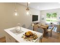 Modern kitchen island with sink and dining table, perfect for entertaining and casual dining at 7622 Indigo Palms Way, Johns Island, SC 29455