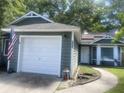 Inviting home featuring a well-maintained lawn, a white garage door, and fresh exterior paint at 8254 Timberidge Ct, North Charleston, SC 29420