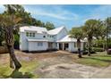 Eye-level exterior view of home with white siding, bright metal roof, and under construction landscaping at 931 Kincade Dr, Mount Pleasant, SC 29464