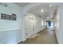 Well-lit condo hallway showcasing unit numbers and an arched entrance, combining functionality with a welcoming design at 1025 Riverland Woods Pl # 904, Charleston, SC 29412