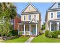 Charming yellow two-story home with a cozy front porch and manicured lawn, exuding curb appeal at 104 Hyacinth St, Summerville, SC 29483