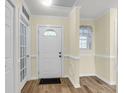 Bright foyer with a decorative front door, wood-look floors, and soft yellow walls with white trim at 1060 Oakcrest Dr, Charleston, SC 29412