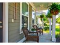 Charming front porch with cozy seating, hanging ferns, and a welcoming atmosphere at 1061 Ashley Gardens Blvd, Charleston, SC 29414