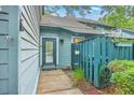 Cozy entryway showcasing a well-lit entrance with a storm door and green fence at 1115 Shadow Lake Cir, Mount Pleasant, SC 29464