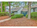 Exterior view of a charming townhome with mature landscaping and a walkway at 1115 Shadow Lake Cir, Mount Pleasant, SC 29464