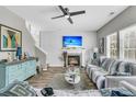 Comfortable living room with a fireplace, ceiling fan, and natural light from the many bright windows at 113 Southernwood Dr, Ladson, SC 29456