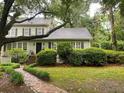 Charming home with a lush front yard, green bushes, and a brick pathway leading to the front door at 116 W 5Th South St # D, Summerville, SC 29483