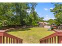 Large backyard features lush green grass, mature trees, a wood fence and playset with a slide at 117 Canaberry Cir, Summerville, SC 29483