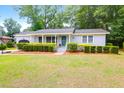 Charming one-story home featuring a well-manicured lawn and beautiful front yard landscaping at 1416 Glencoe Dr, Mount Pleasant, SC 29464