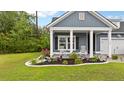 Charming front yard featuring a well-manicured lawn and a cozy front porch with rocking chairs at 148 Haverhill St, Summerville, SC 29486