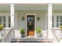 Welcoming front porch with a craftsman-style door, stylish light fixtures, and potted plants at 1527 Wando View St, Charleston, SC 29492