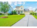 Lovely home with a well-maintained lawn and a charming front porch, complemented by an attached garage and a paved driveway at 1545 Calaveras Cir, Mount Pleasant, SC 29466
