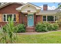 A lovely red brick home entrance with stylish wood-accented shutters and a bright blue door at 1603 Culpepper Cir, Charleston, SC 29407