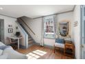 Bright room with hardwood floors, staircase, large window and comfortable seating area at 166 1/2 Queen St, Charleston, SC 29401
