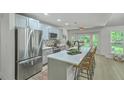 Well-lit kitchen boasts stainless steel appliances, an island with bar seating, and views of the backyard at 169 Southwold Cir, Goose Creek, SC 29445