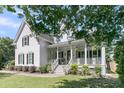 Elegant home with a spacious porch, detailed railings, and a well-maintained lawn and landscaping at 1761 Old Military Rd, Charleston, SC 29412