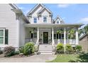 Inviting front porch with stylish columns, ceiling fans, and lush landscaping, perfect for relaxing outdoors at 1761 Old Military Rd, Charleston, SC 29412