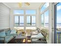Bright sunroom with ocean views and cozy seating at 216 W Arctic Ave # 9, Folly Beach, SC 29439