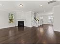 Bright living room featuring hardwood floors, a fireplace, and access to stairs leading to the upper level at 2200 Hamlin Sound Cir, Mount Pleasant, SC 29466