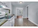 Modern kitchen featuring white cabinets, tiled floors, granite counters, and ample natural light at 2350 Kent Ave, North Charleston, SC 29405