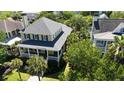 Aerial view of yellow two-story home with palm trees and well-maintained landscaping at 2449 Daniel Island Dr, Daniel Island, SC 29492