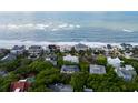 Aerial view of beachfront homes nestled between lush greenery and ocean waves, perfect for coastal living and enjoying the ocean breeze at 26 Beachwood East, Isle of Palms, SC 29451