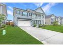 Beautiful two-story home boasts a manicured lawn, double porch, and convenient attached garage at 300 Saxony Loop, Summerville, SC 29486