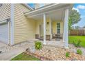 View of the front porch with classic columns, seating area, and decorative rock landscaping at 3055 Nantuckett Ave, North Charleston, SC 29420