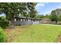 An inviting gray brick house features a lush green lawn with mature trees at 323 Amy Dr, Goose Creek, SC 29445