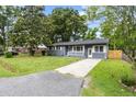 A charming gray house with a green lawn is situated on a lovely lot with mature trees at 323 Amy Dr, Goose Creek, SC 29445