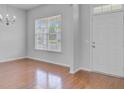 Bright, vacant room with hardwood floors, a front door, and large windows for natural light at 334 Cicadas Song Dr, Moncks Corner, SC 29461