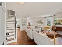 Bright living room features hardwood floors, white sofas, and a staircase in an open-concept design at 5 Smith St, Charleston, SC 29401