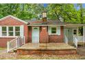 Close up of a charming brick home with a light blue door and shutters and black iron fence at 5056 Piedmont Ave, North Charleston, SC 29406