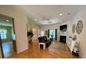 Cozy living room with a ceiling fan, fireplace, and hardwood floors at 7517 Whispering Oak Dr, Hanahan, SC 29410