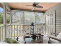 Relaxing screened-in porch featuring comfortable seating, a ceiling fan, and a tranquil view at 7921 Cricket Ct # 305 E, North Charleston, SC 29418