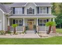 Inviting front porch featuring classic columns and decorative wreaths, creating a warm welcome at 9524 Markley Blvd, Summerville, SC 29485