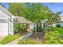 Beautiful home exterior with well-manicured landscaping and a charming walkway to the front door at 104 S Ansel Xing, Goose Creek, SC 29445