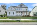 Beautiful light blue two-story home boasts a manicured lawn and charming curb appeal at 1095 Saltwater Cir, Johns Island, SC 29455